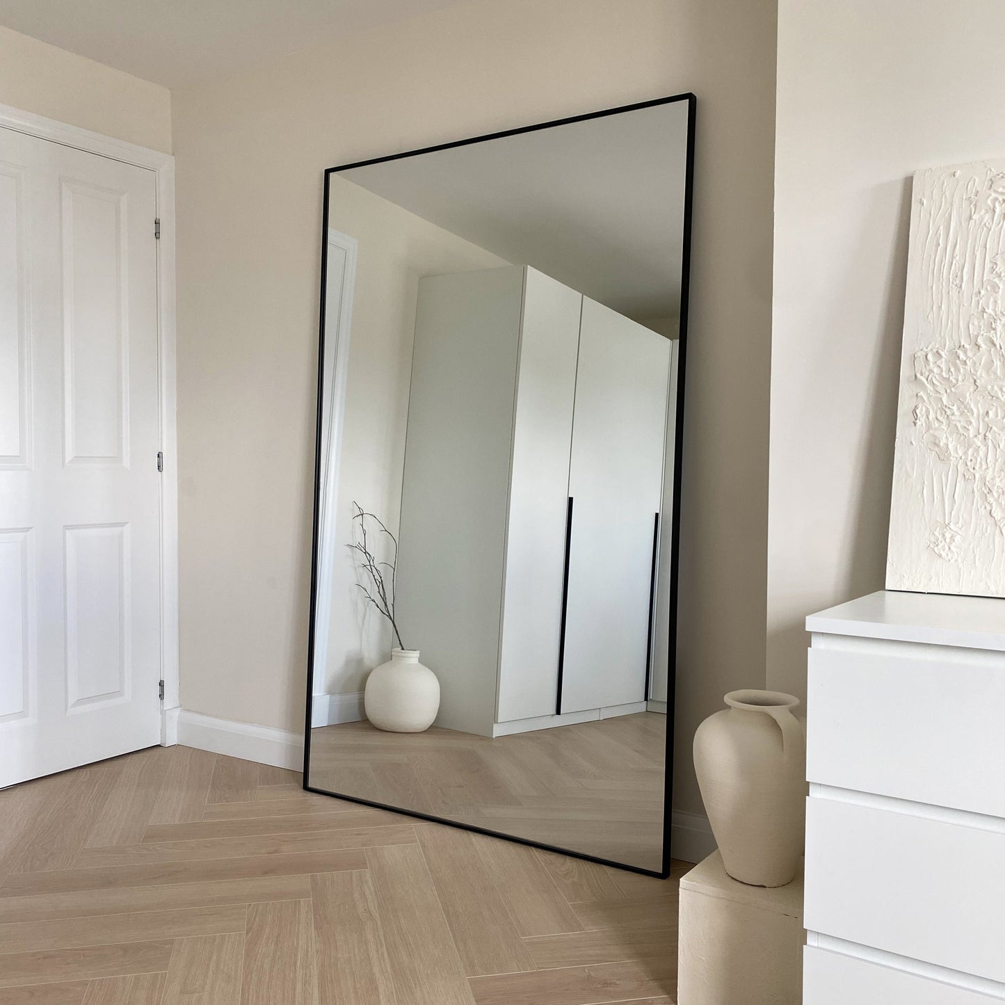 Full Length Black Extra Large Metal Mirror beside plinths